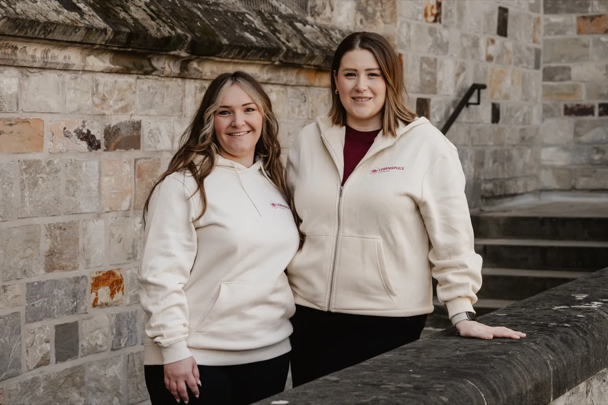 Zwei Mitarbeiterinnen von Lebenspuls im Lebenspuls-Hoodie