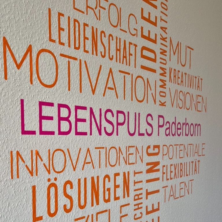 Wandgestaltung mit bunten Wörtern zu Motivation, Innovation und Zielen von Lebenspuls Paderborn.