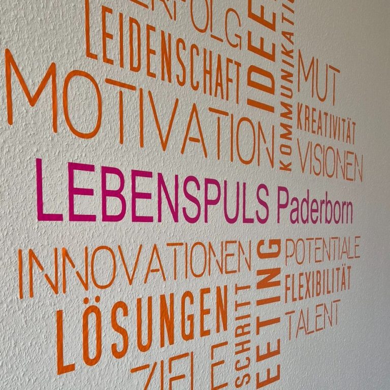 Wandgestaltung mit bunten Wörtern zu Motivation, Innovation und Zielen von Lebenspuls Paderborn.